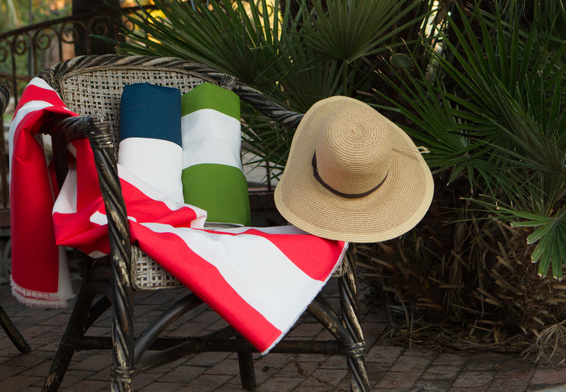 photo of large outdoor striped fabric laying on pool patio chair