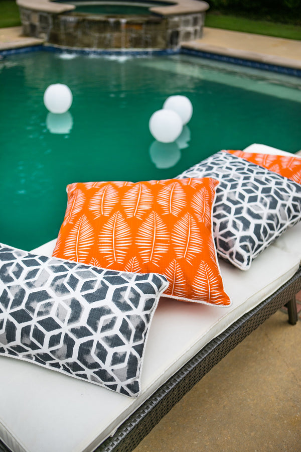 orange outdoor fabric with tropical leaf made into outdoor pillows