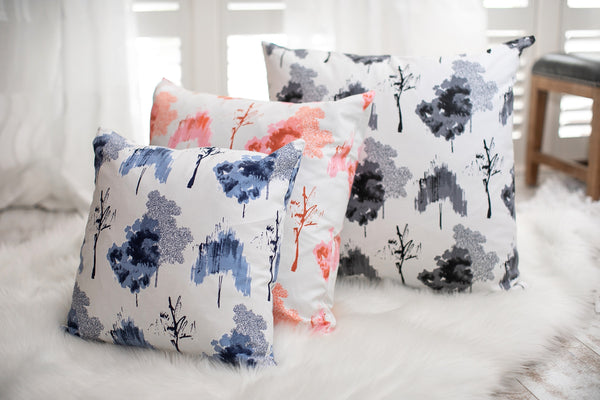 picture of white, blue, red, and black trees on fabric sitting in a clean white modern sleek room