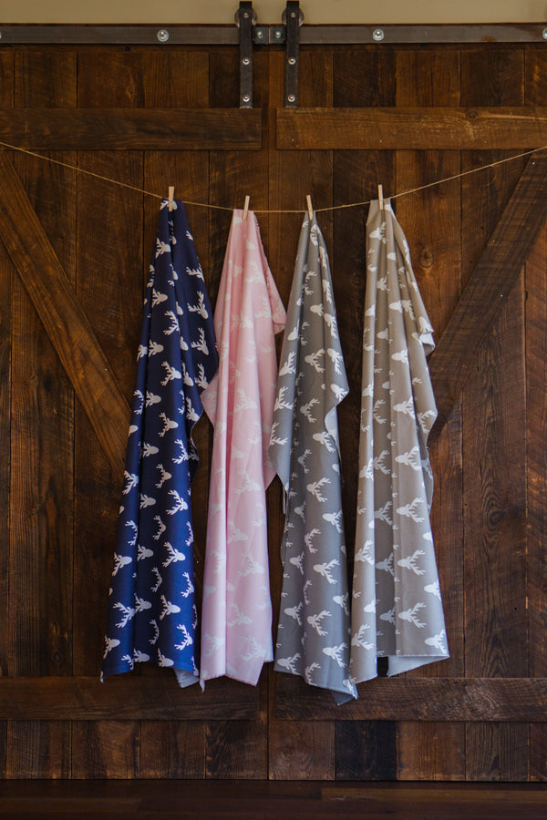 photo of deer fabrics hanging on farm wooden barn door