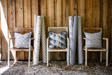 photo of mid western desert style fabrics with mountains, alpacas, cacti, cactus sitting in chairs next to old barn wood wall 
