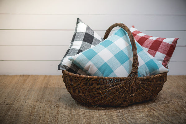 photo of pillows made with large plaid pattern outdoor fabric sitting in basket