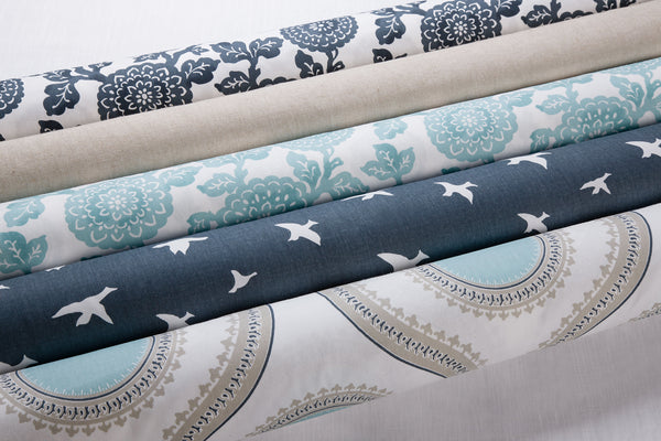 picture of bird pattern, flower pattern, and plain fabric rolls with white background